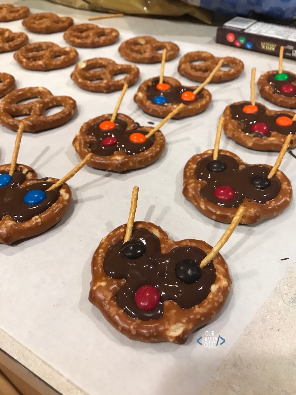 A picture of chocolate reindeer pretzels on wax paper.