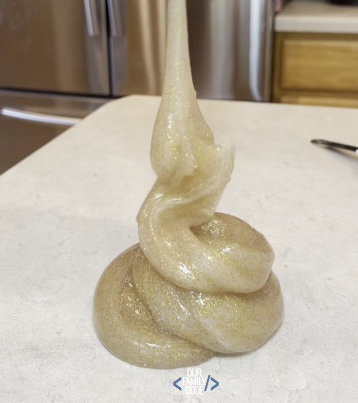 A picture of gold glitter slime falling into a pile.