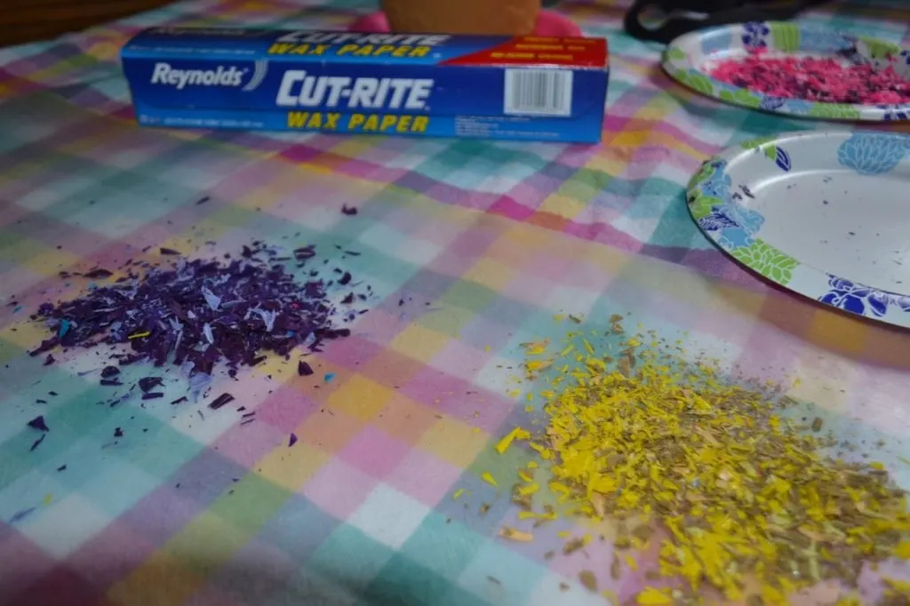 A picture of purple and yellow crayon shavings on wax paper.