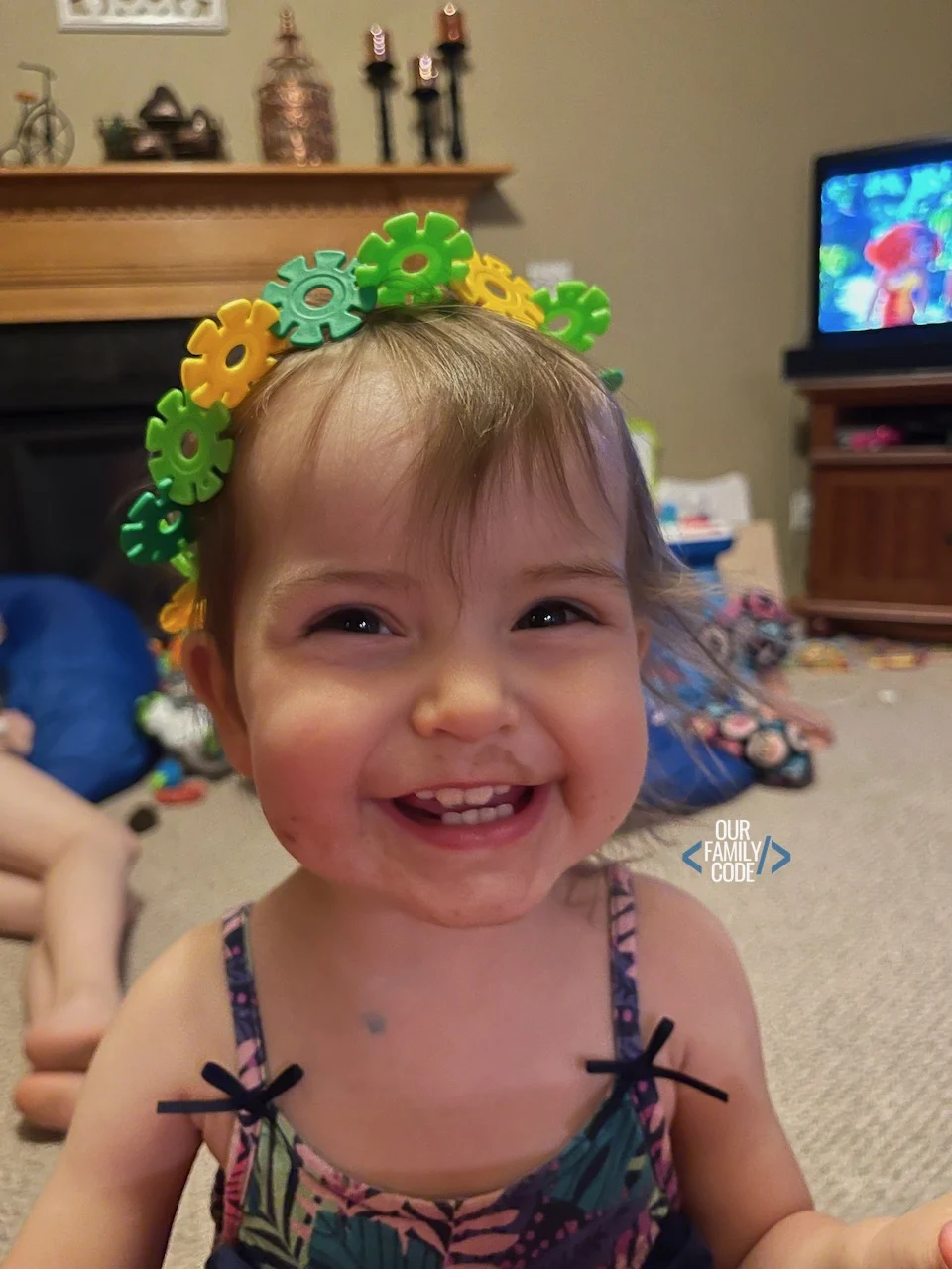 A toddler with a chocolate face and brain flakes crown.