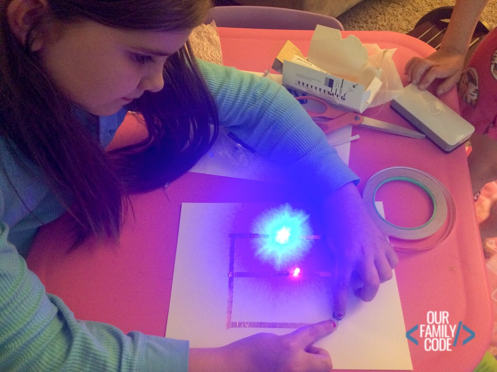 Child experimenting with a pumpkin paper circuit