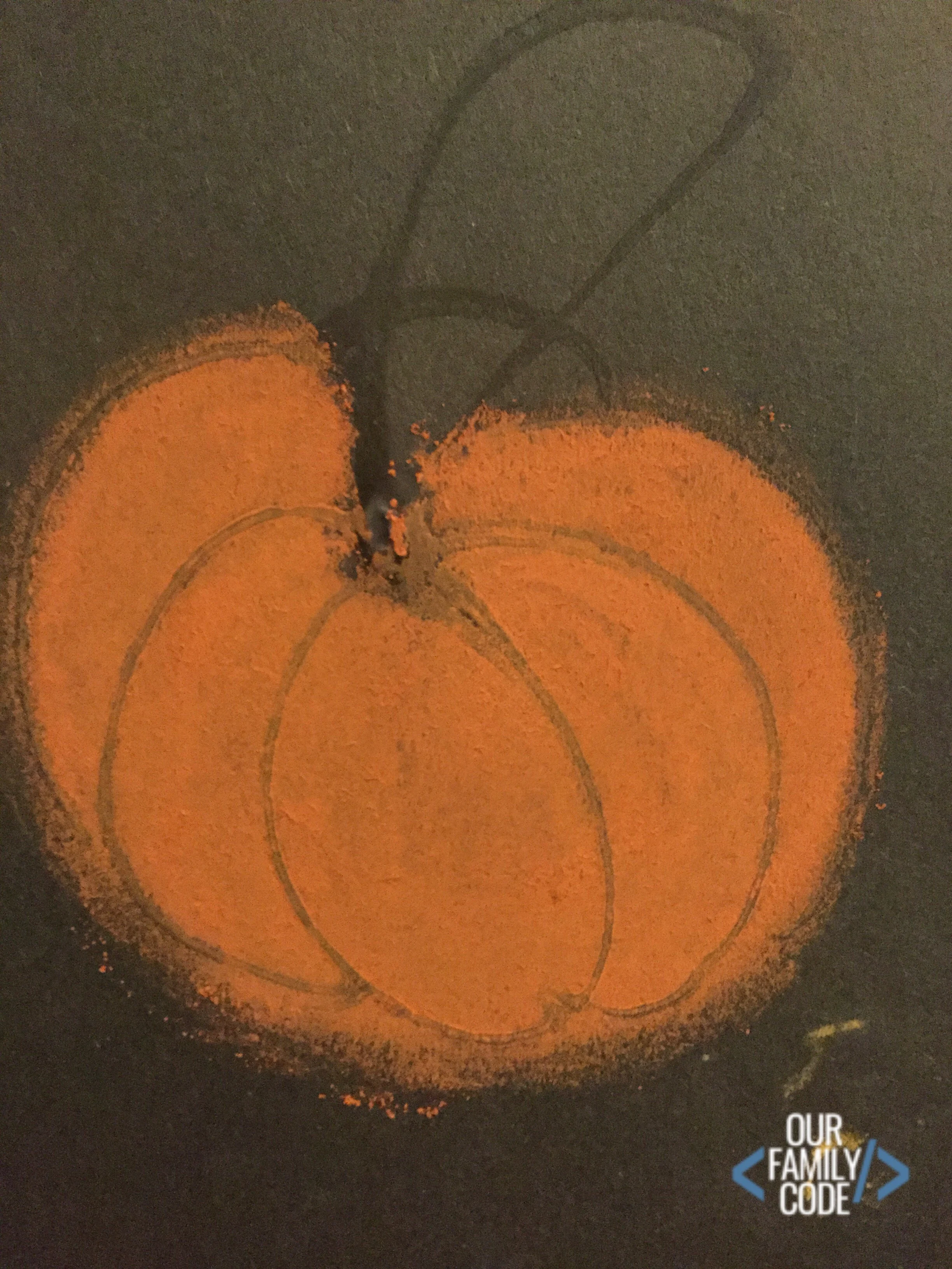 A picture of a pumpkin made with glue and blended with orange chalk.