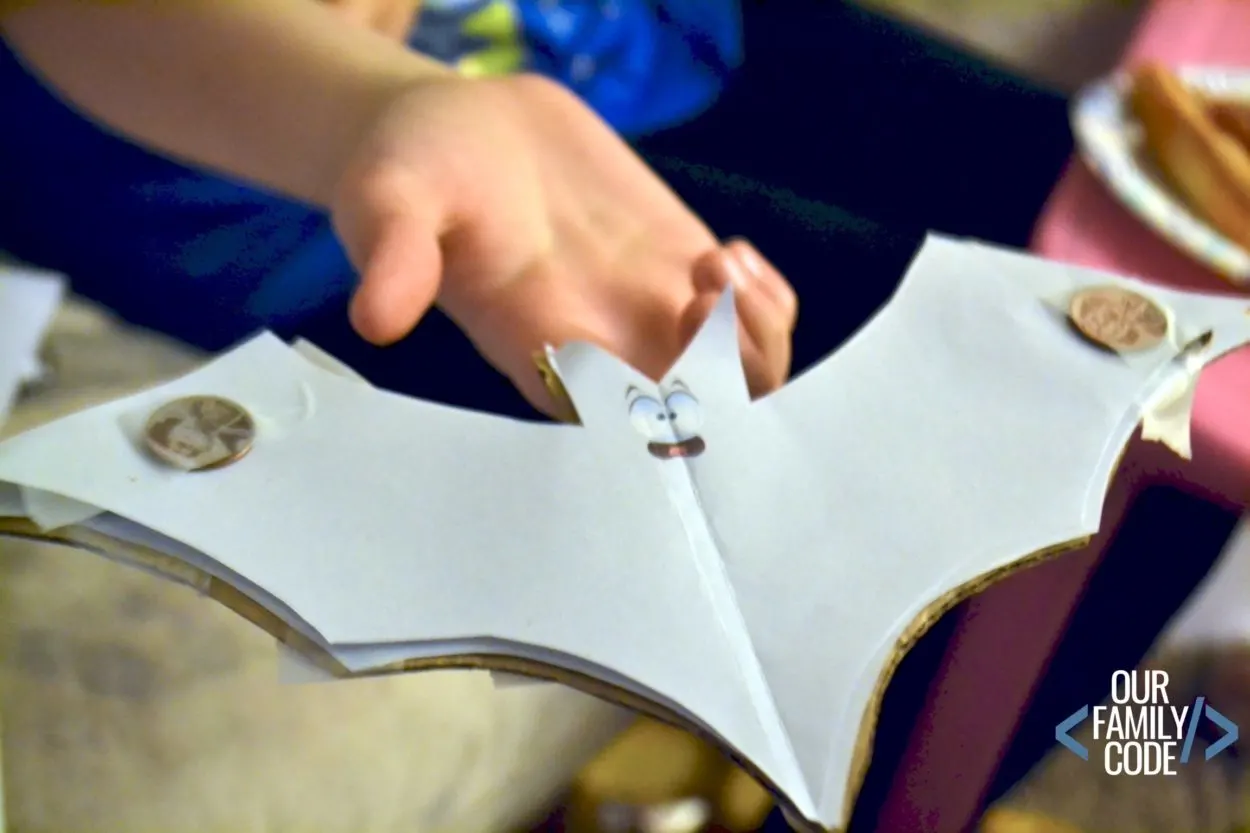 A photo of a kid balancing a bat on their hand for a Stellaluna book activity. 