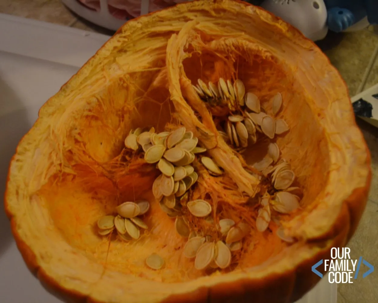 large pumpkin cut in half with lots of seeds