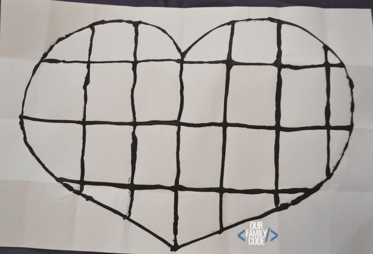 A picture of a logical reasoning patchwork heart activity outlined in black glue.