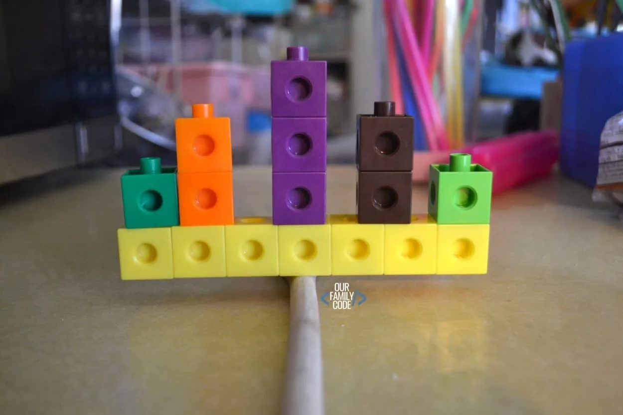 A picture of unifix cubes balancing on a stick for a preschool STEM challenge.
