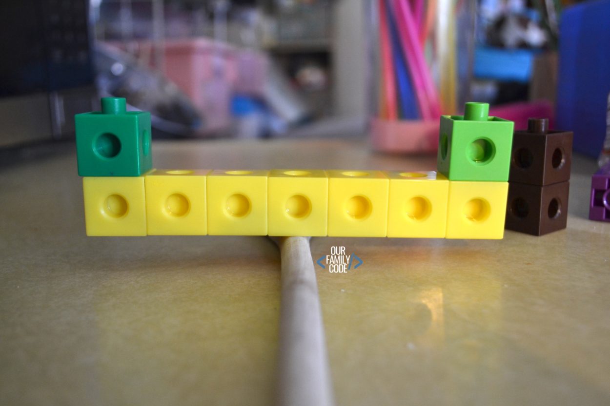 A picture of unifix cubes balancing on a stick for a preschool STEM challenge.