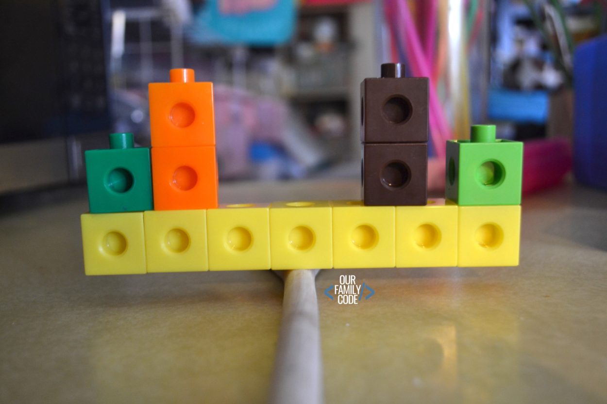 A picture of unifix cubes balancing on a stick for a preschool STEM challenge.