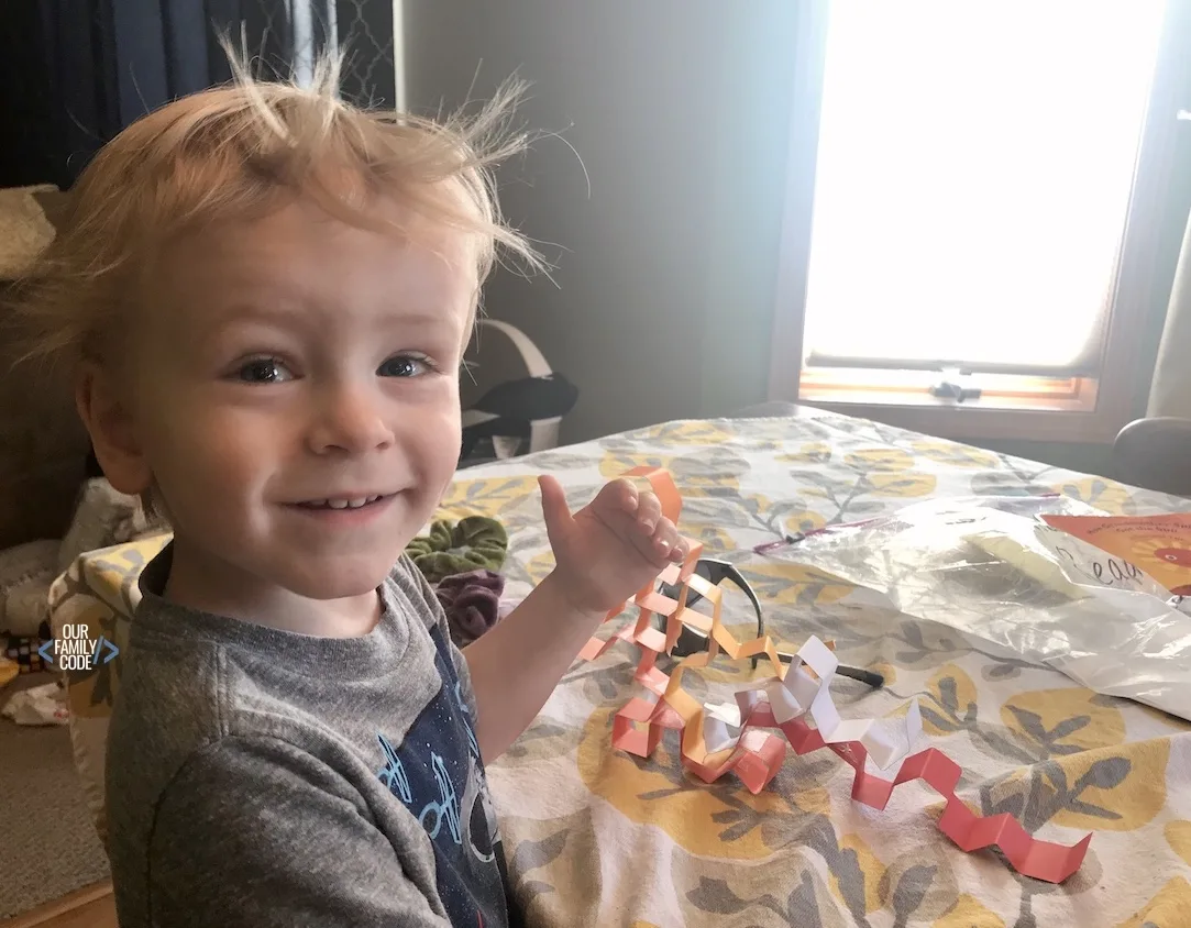 A young boy playing with a dragon curve fractal math art.