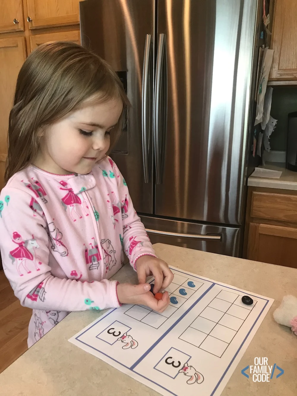 A picture of a kid putting jelly beans on math ten frames.