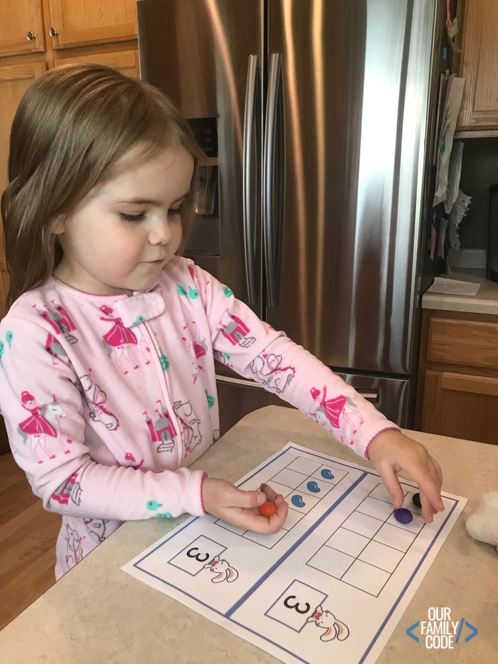 A picture of a kid placing jelly beans on an easter ten frame.