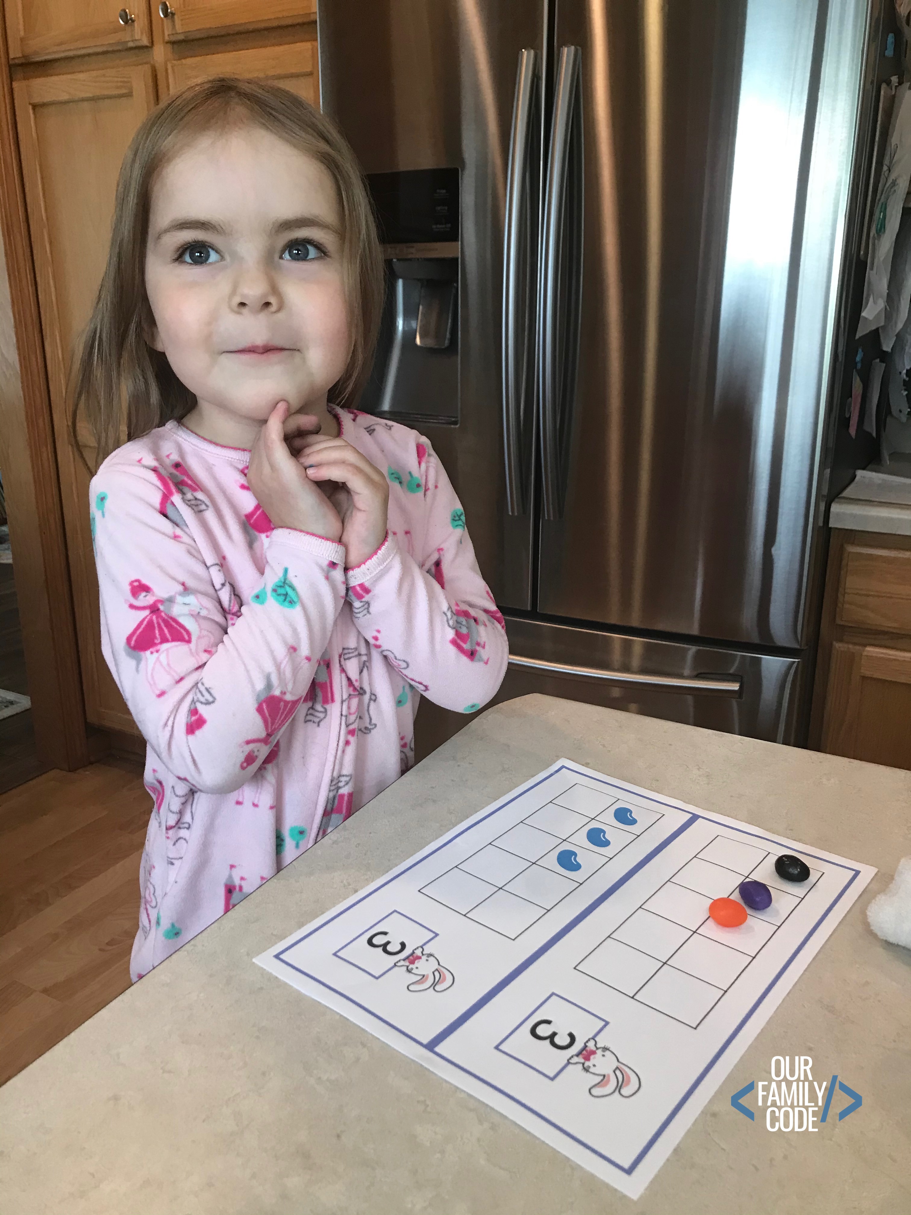 A girl using jelly beans on ten frames to count.