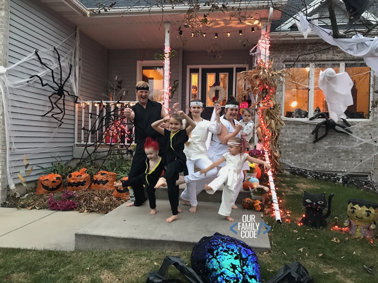 A picture of a family dressed up in Cobra Kai and Miyagi-do costumes for Halloween.