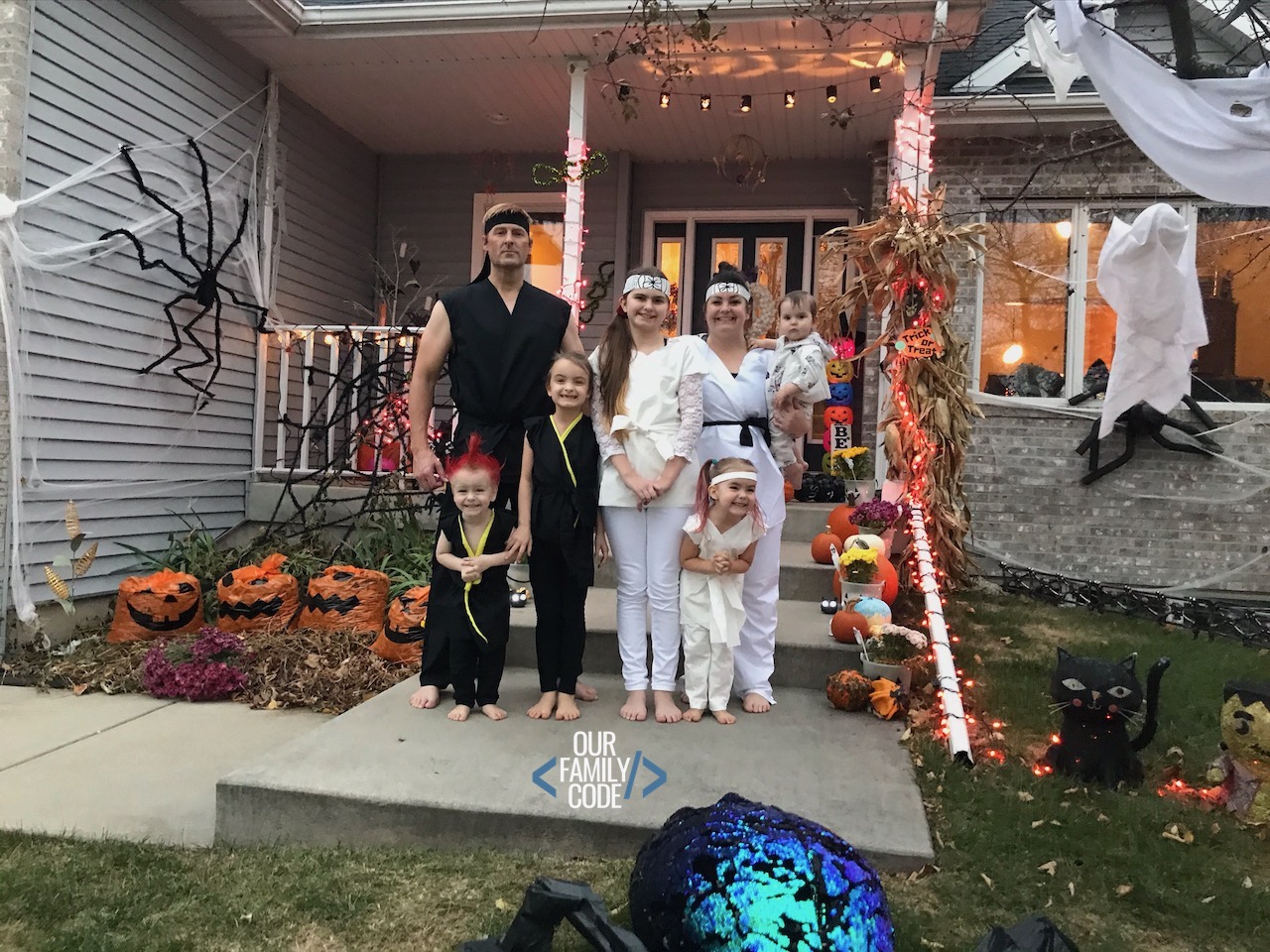 A picture of a family dressed up as cobra kai and miyagi-do for halloween.