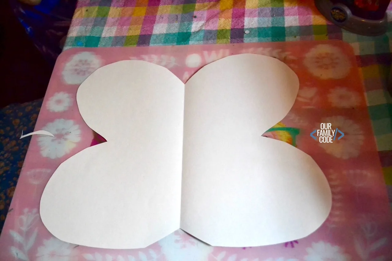 A picture of a blank butterfly shape cut out of construction paper.