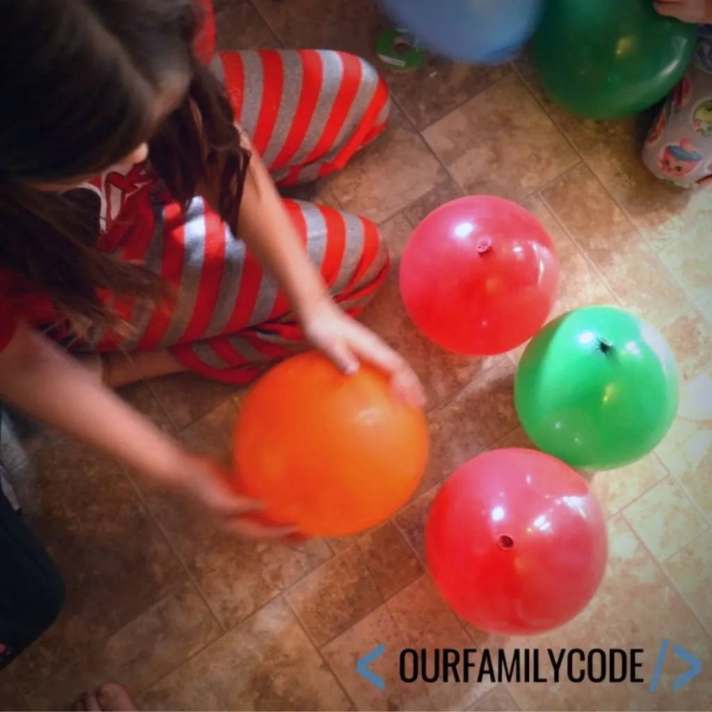 A picture of two girls trying to build a balloon tower.