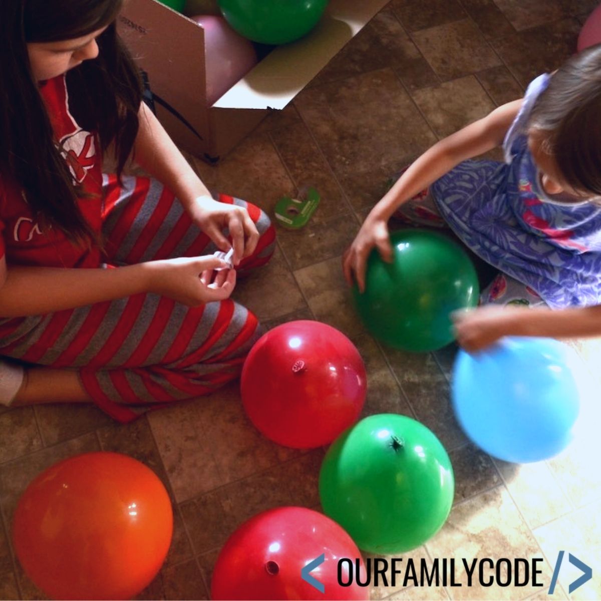 A picture of two girls trying to build a balloon tower.