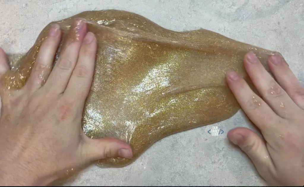 A picture of gold glitter slime being kneaded.