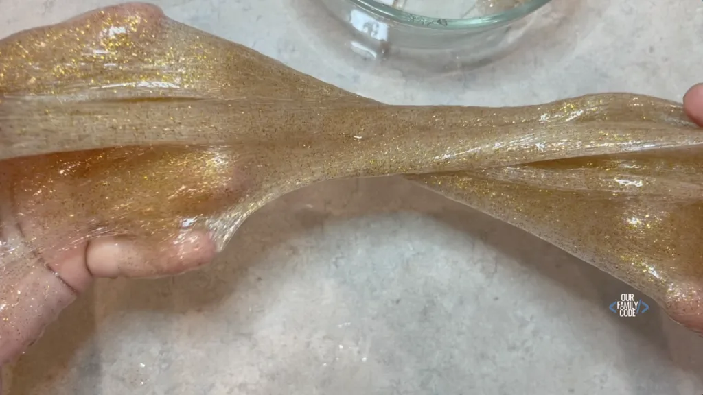 A picture of glitter slime being stretched.