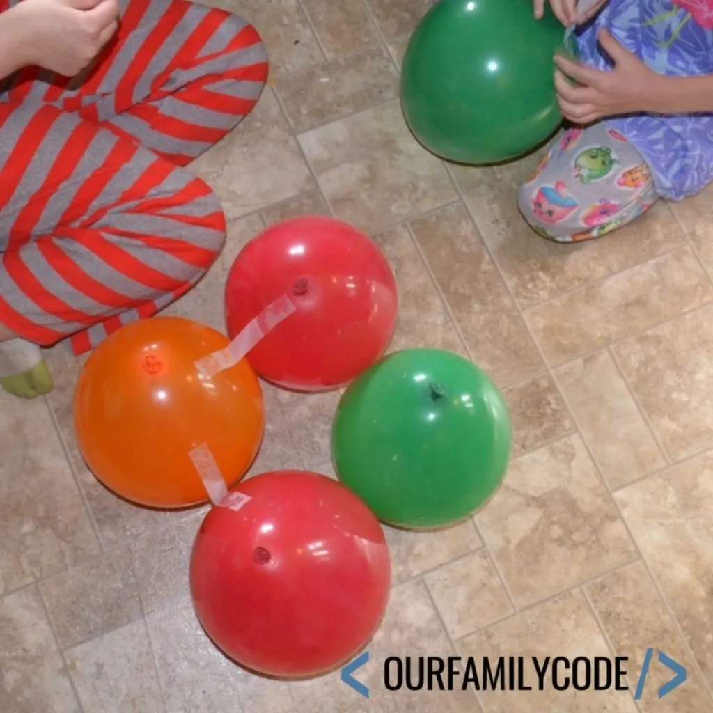 A picture of two girls trying to build a balloon tower.