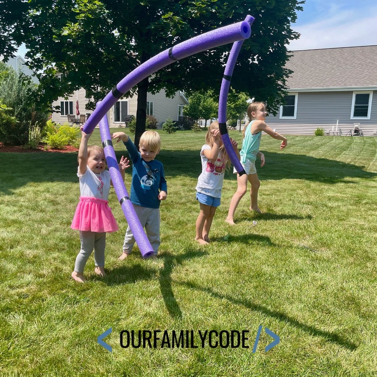 A picture of kids throwing javelin pool noodles in the backyard.